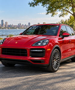 Red Porsche Cayenne 9Y0 with LED headlights parked beside a river